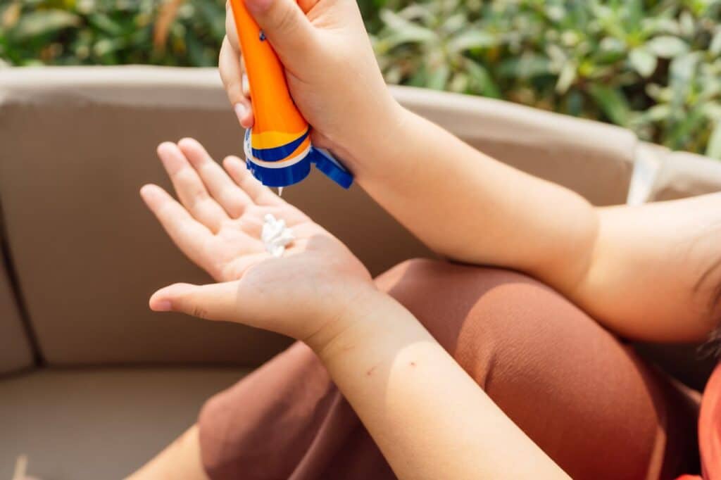 femme appliquant de la crème solaire
