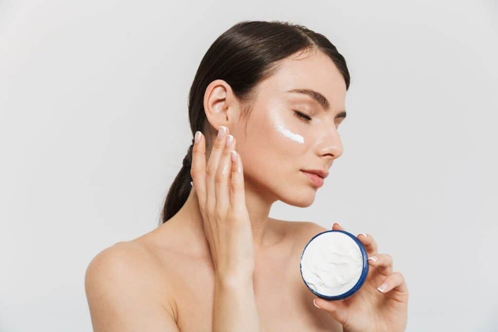 femme appliquant un produit de soin pour hydrater sa peau