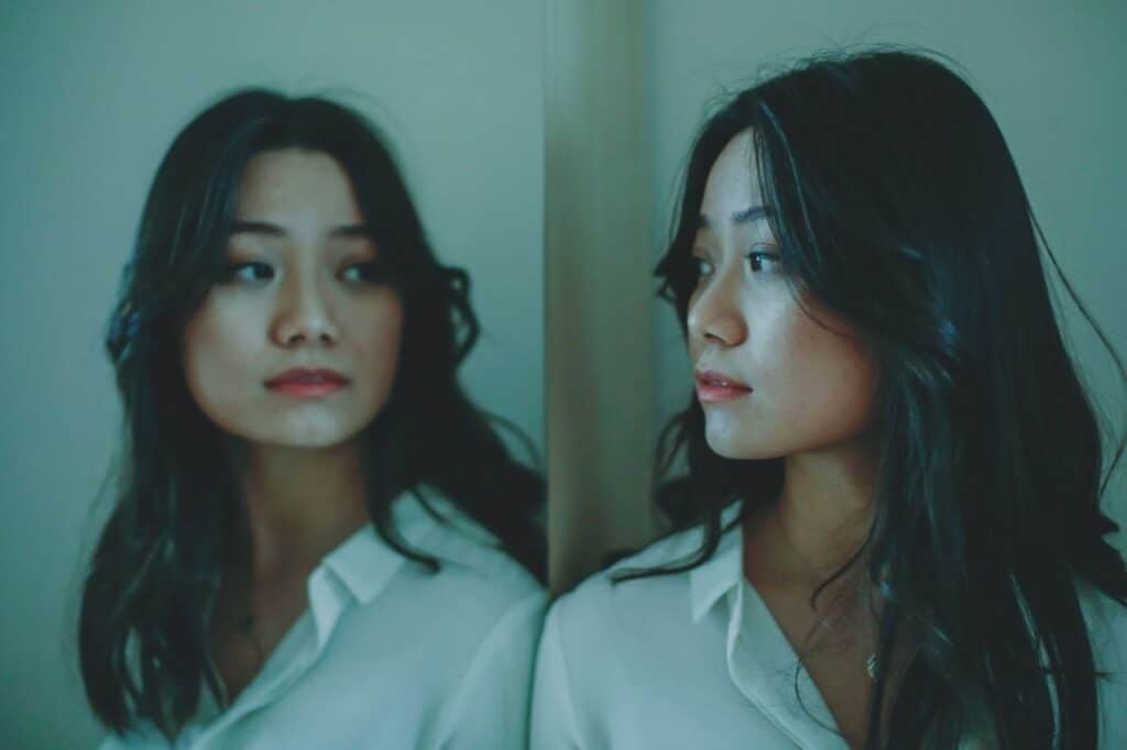 Femme face à son reflet dans le miroir, symbolisant le vide intérieur et la perte de connexion à soi