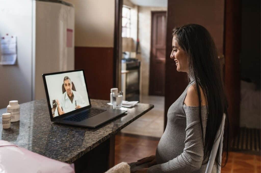 femme enceinte en téléconsultation discutant d'info trouvées sur le site du crat
