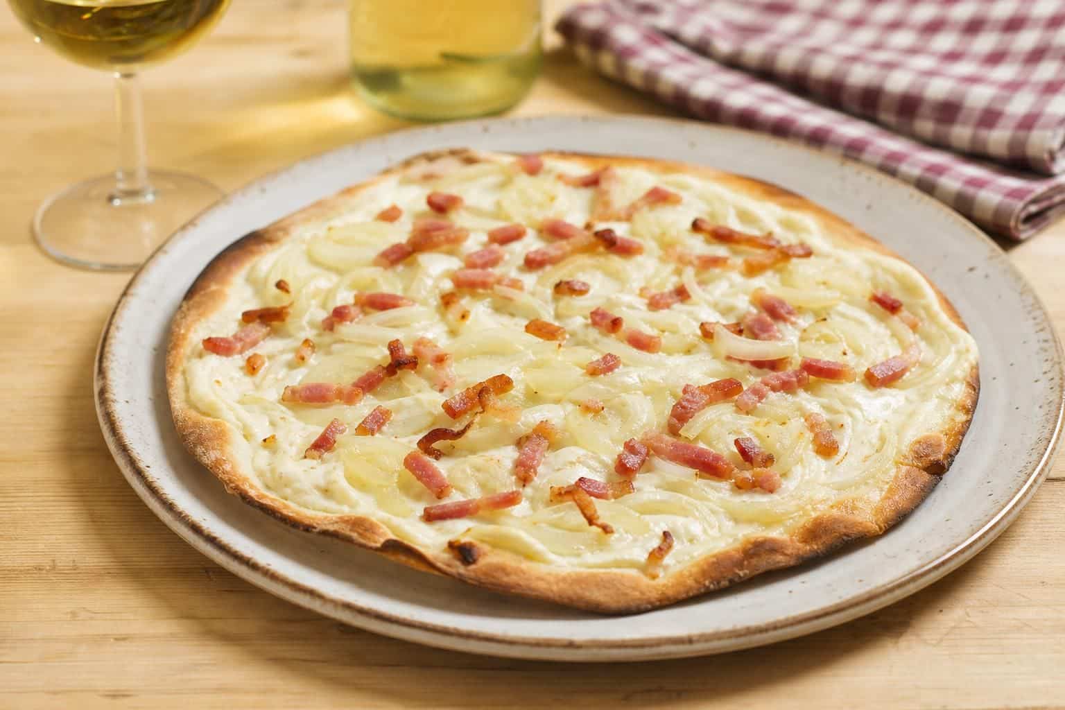 découvrez notre recette traditionnelle de flammekueche alsacienne, une tarte fine et croustillante garnie de crème, oignons et lardons, pour un goût authentique d'alsace.